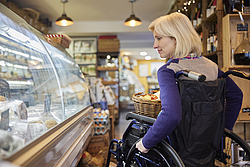 Femme en fauteuil roulant dans un magasin.