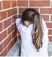 Jeune fille face au mur.