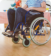 Une femme prépare à manger pour une personne se déplaçant en fauteuil roulant.